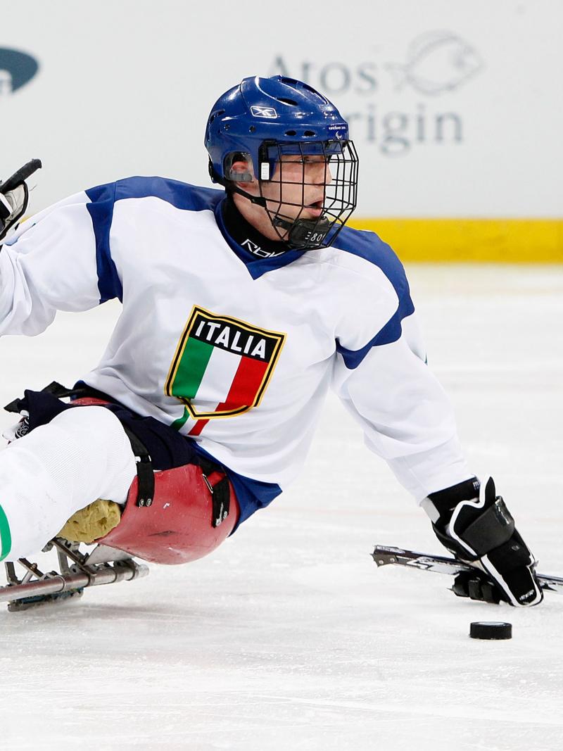 A picture of a man in a sledge practising Ice Sledge Hockey.