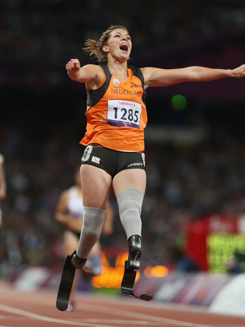 A picture of a woman on the running track celebrating with her hands spread