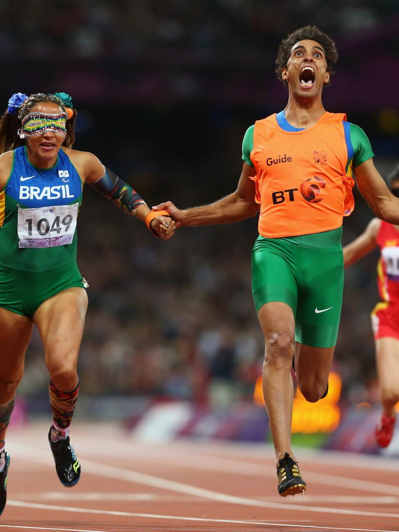 A picture of a woman with the guide running on the track