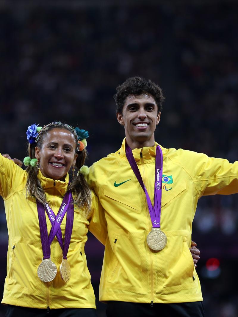 A picture of a woman and a man on a podium with medals around their neck