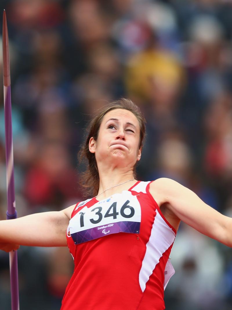 A picture of a woman in the field throwing the Javelin