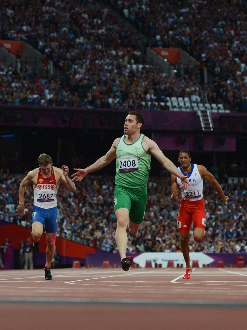 A picture of a man on a track crossing a finishing line