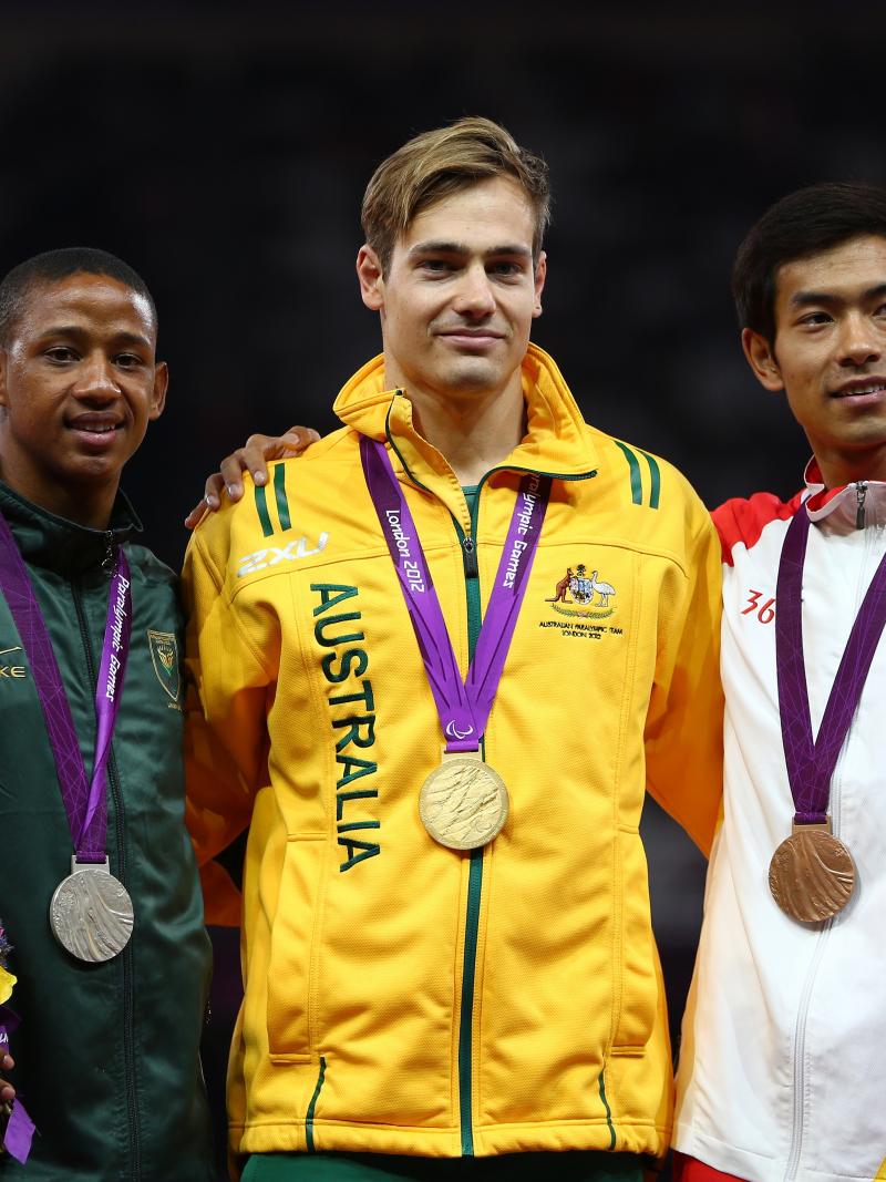 A picture of men on a podium with medals around their neck