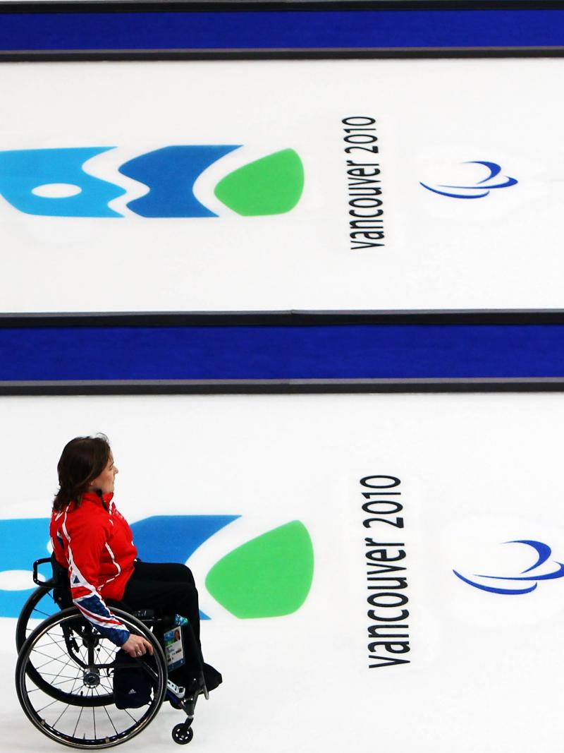 A picture of a woman in a wheelchair playing curling