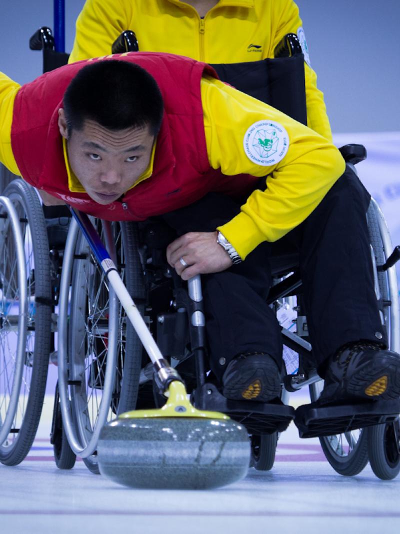 A picture of a man in a wheelchair playing curling