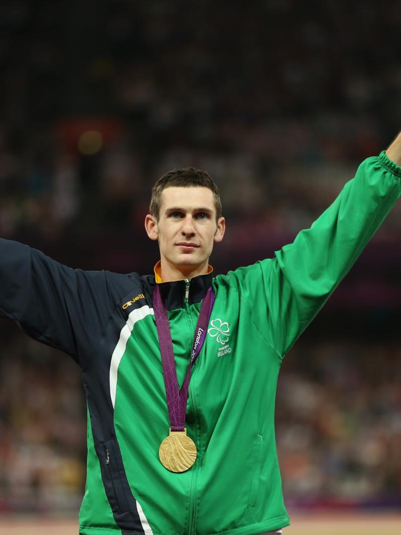 A picture of a man on a podium with a medal around his neck