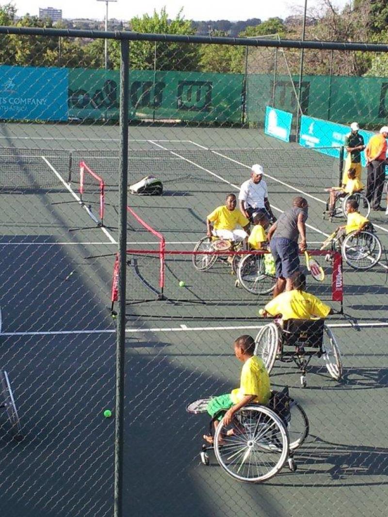 A picture of person in wheelchairs playing tennis