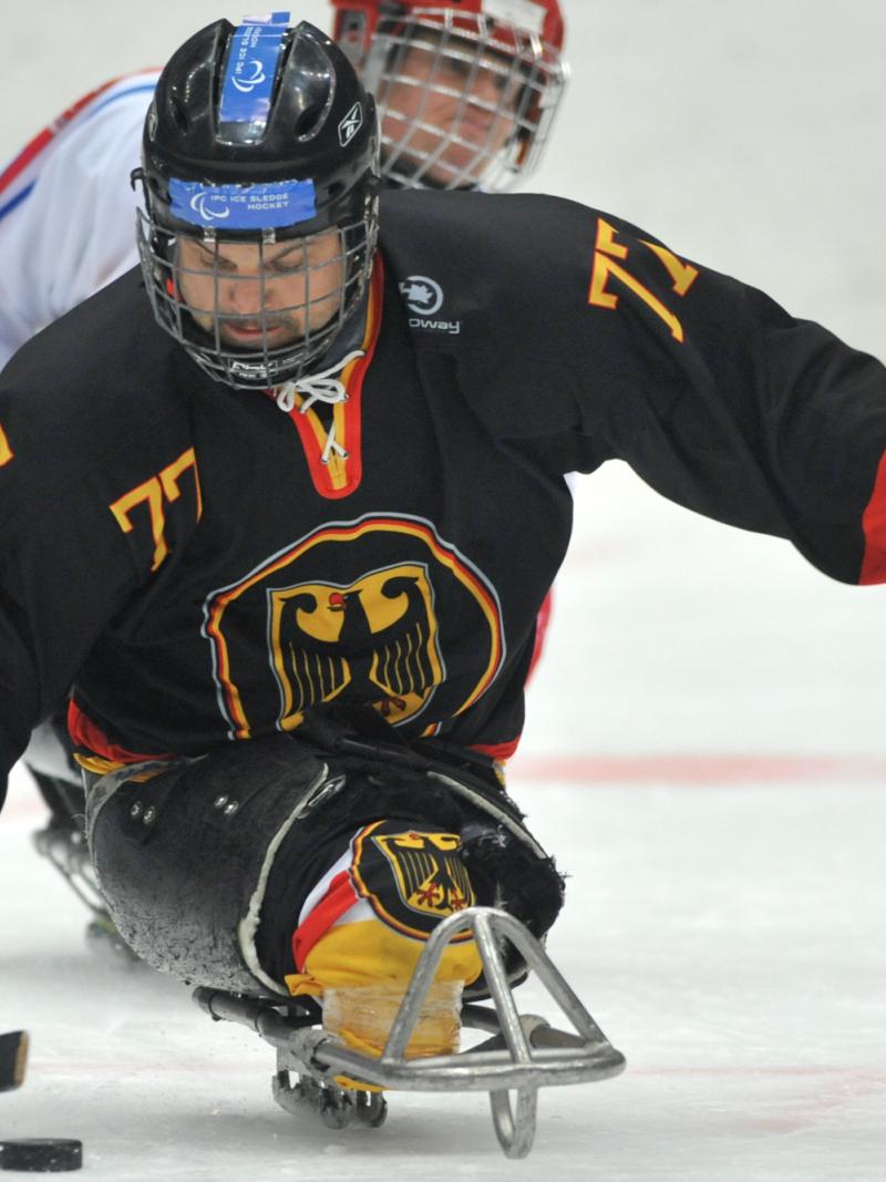 A picture of a man in ssledge playing ice hockey