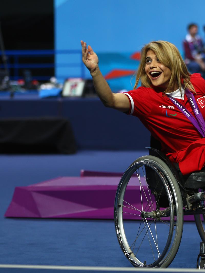 A picture of a woman on a podium with a medal around her neck