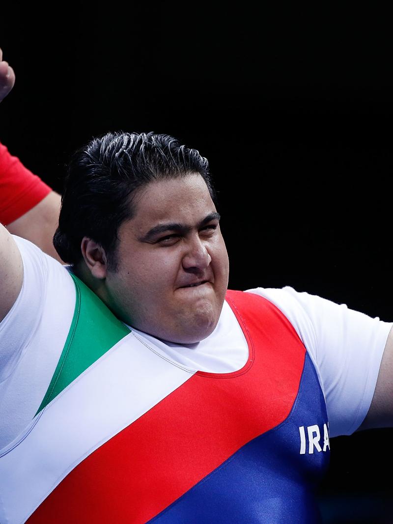 A picture of a powerlifter celebrating victory with his hand up