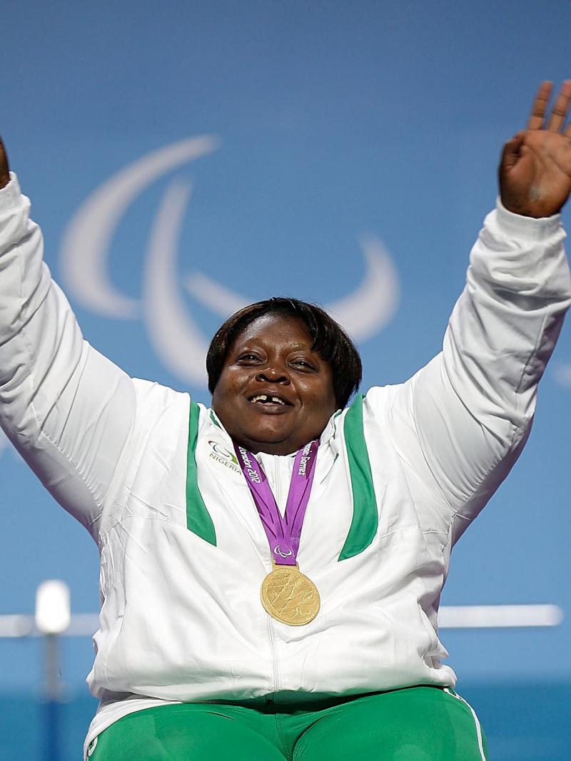 A picture of a woman on a podium with a medal around her neck