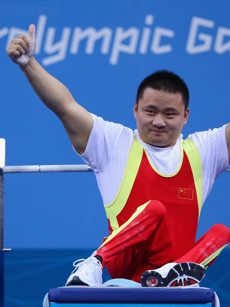 A picture of a man powerlifter on a bench celebrating with his hands up