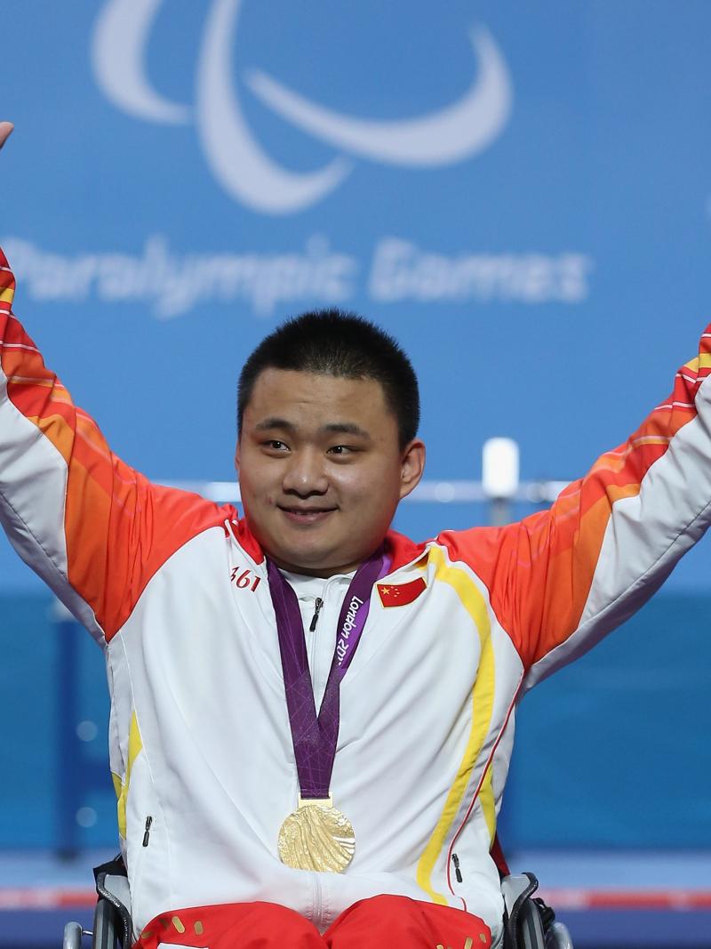 A picture of a man on a podium with a medal around his neck