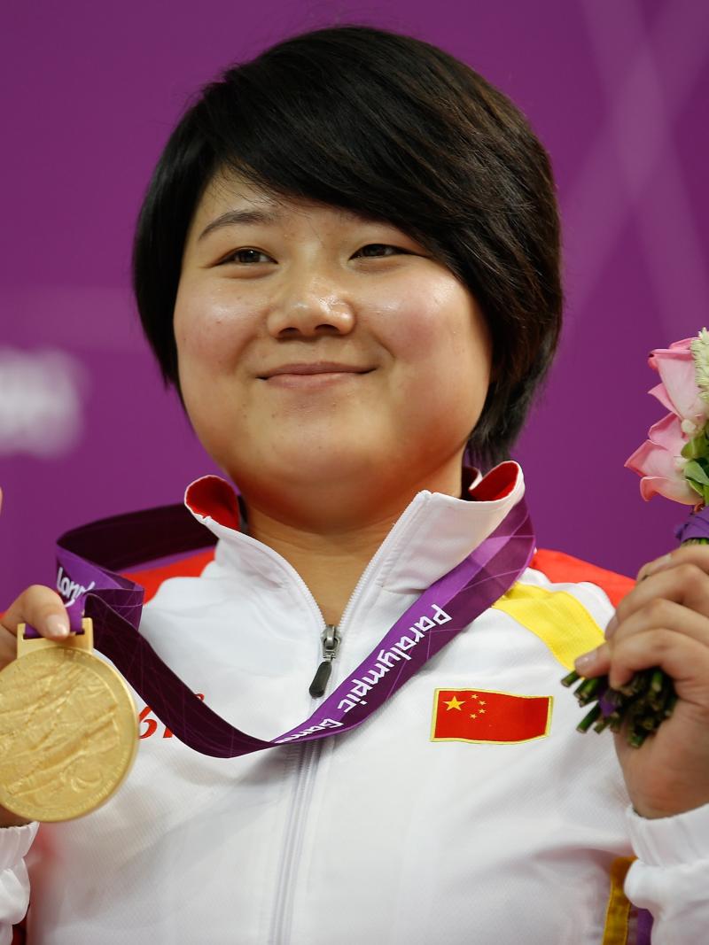 A picture of a woman on a podium with a medal around her neck