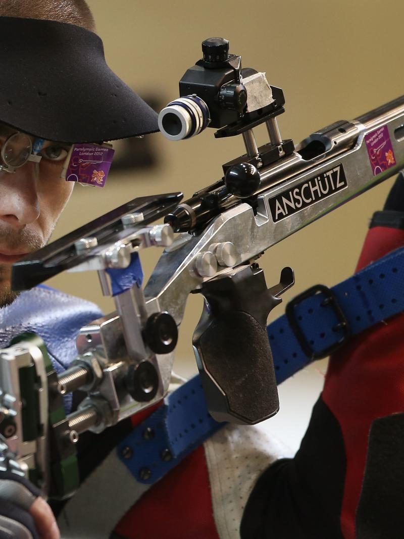 A picture of a man posing with his rifle at the shooting competition