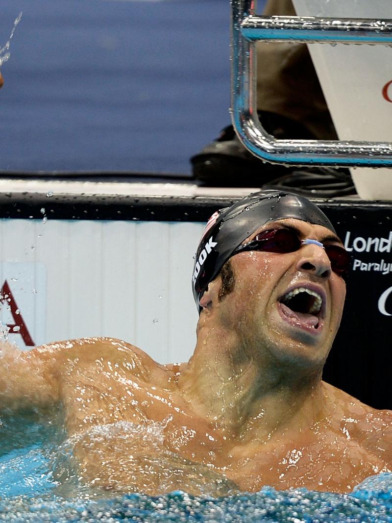 A picture of a man in a pool celebrating his victory