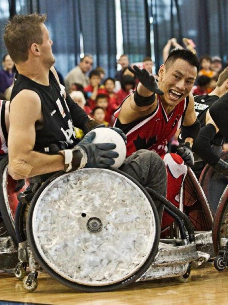 Belgium wheelchair rugby player defends ball against canadian player