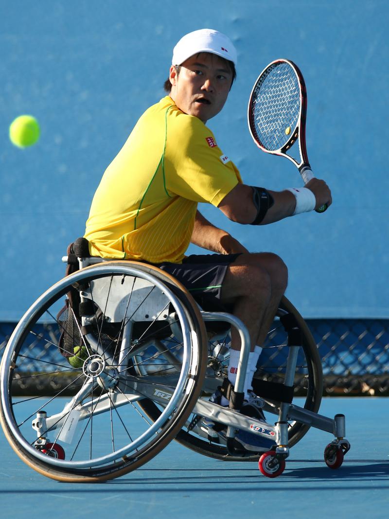 Shingo Kunieda in a wheelchair plays a backhand with his tennis racket
