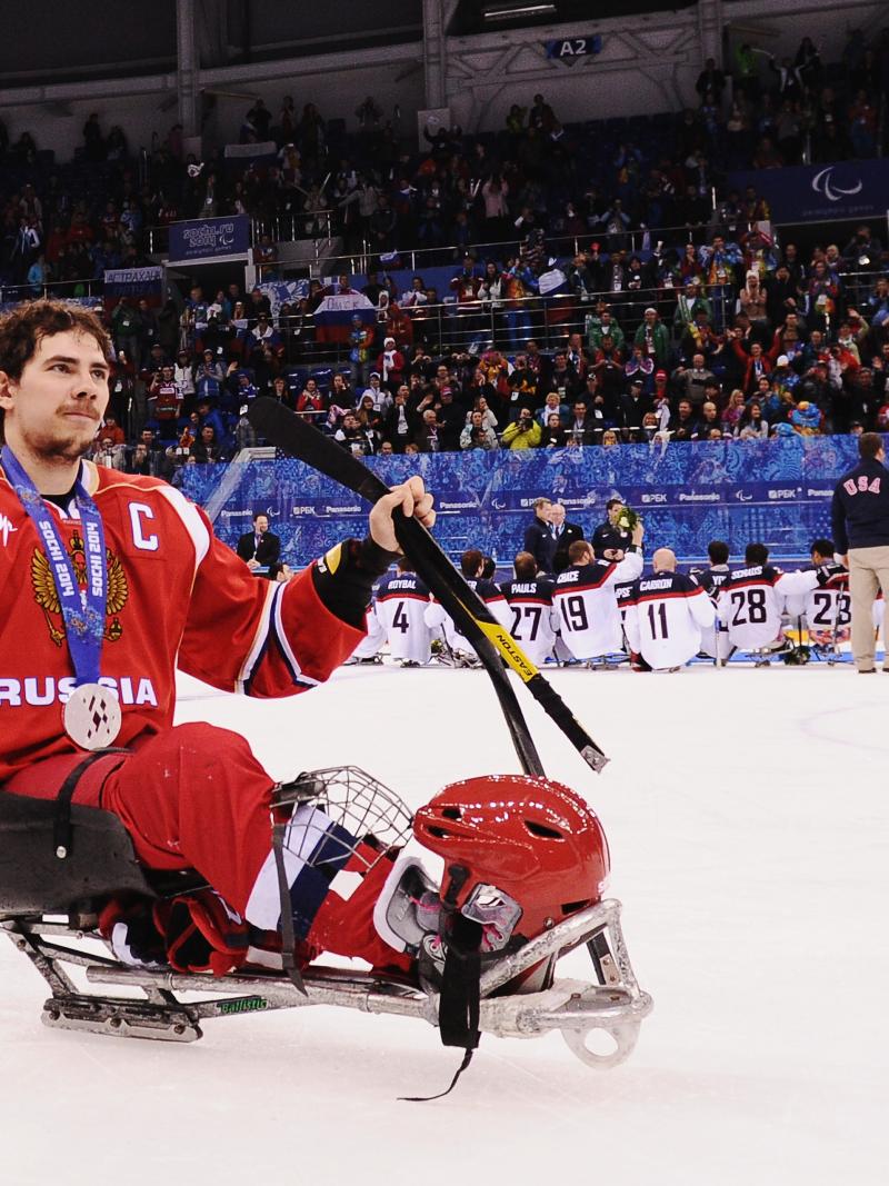 Russian ice sledge hockey player Dmitry Lisov takes his silver medal in stride on the ice at the Sochi 2014 Paralympics.