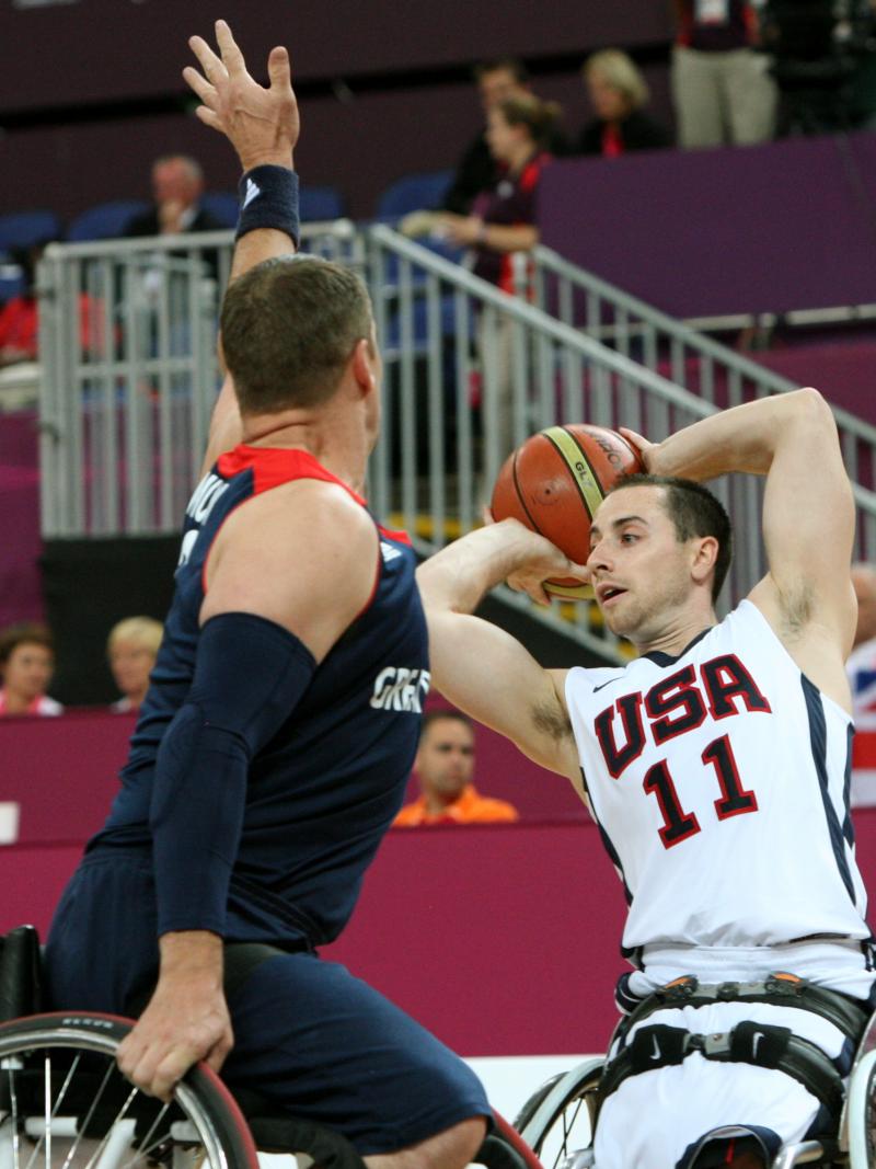 American wheelchair basketball player Steve Serio looks to pass the ball to a teammate.