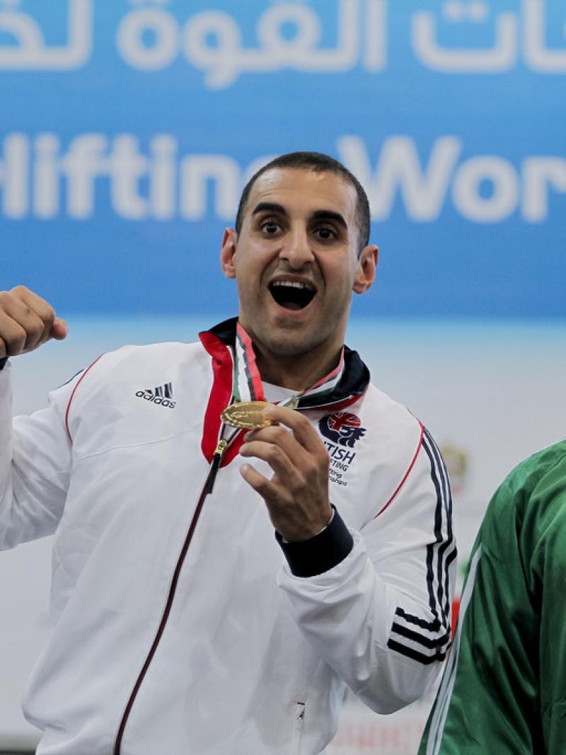 An athlete poses showing his gold medal.