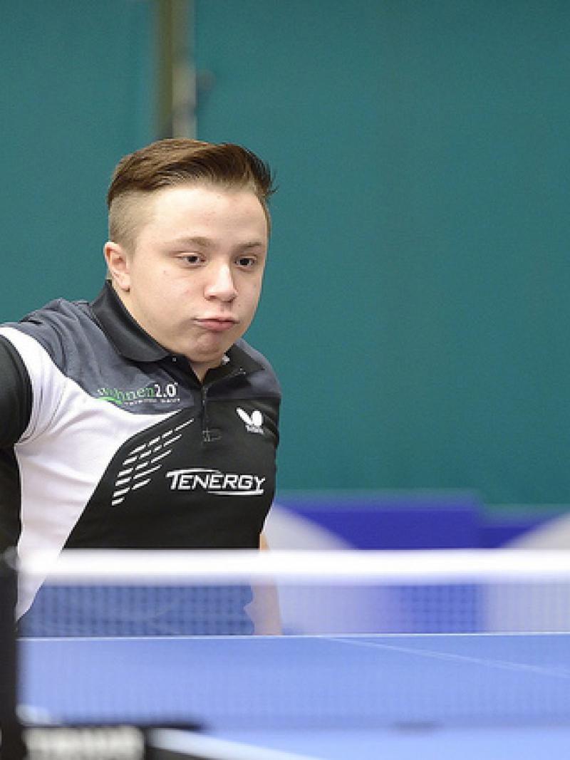 An athlete hits a table tennis ball. 