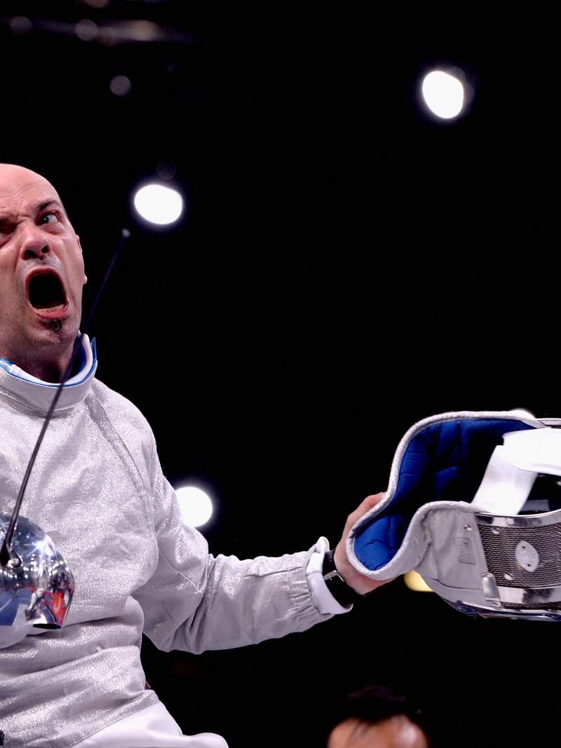 A wheelchair fencer celebrates after a victory.
