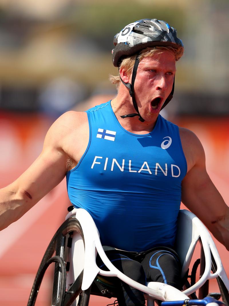 An wheelchair racer shouts out after crossing the finish line in first place.