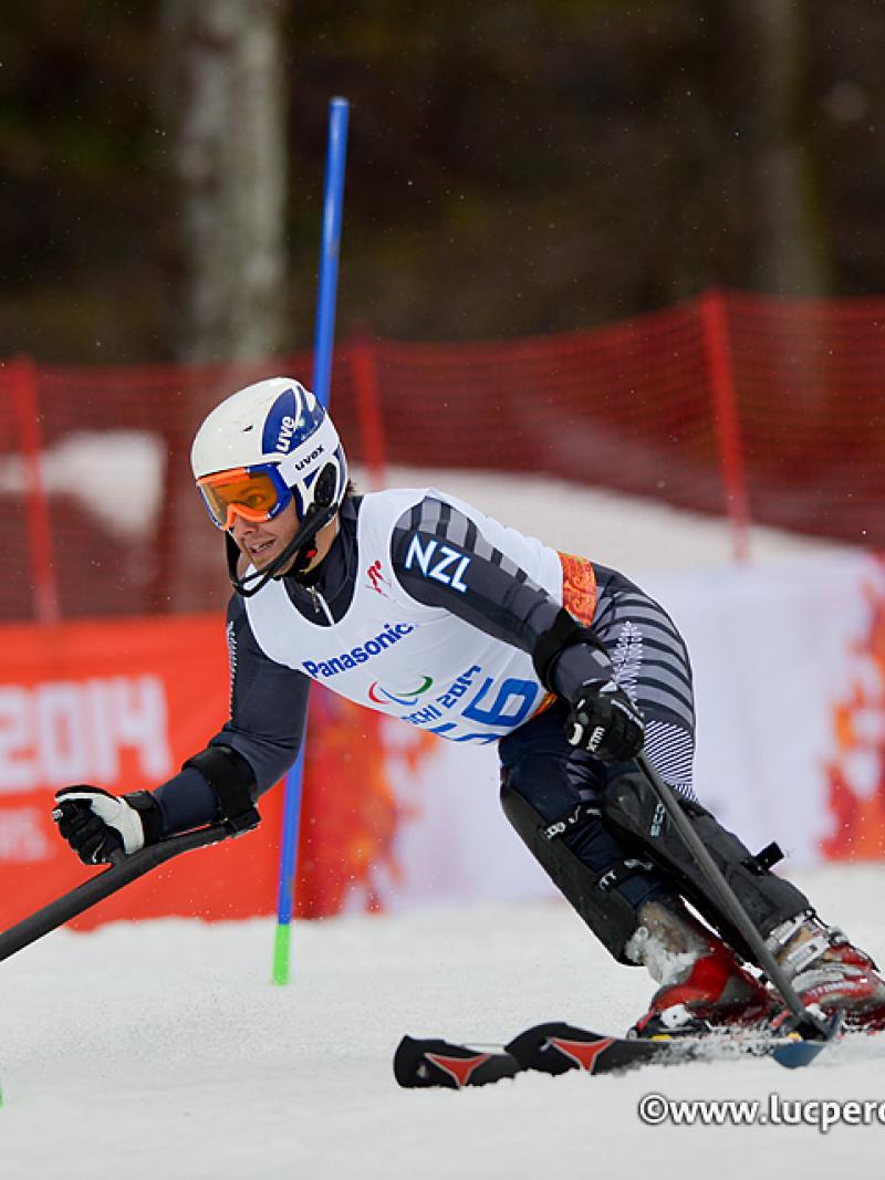 Skiing man curving around some slalom poles