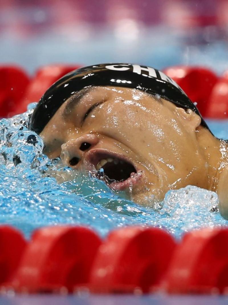 Swimmer in the water breathing between two freestyle strokes