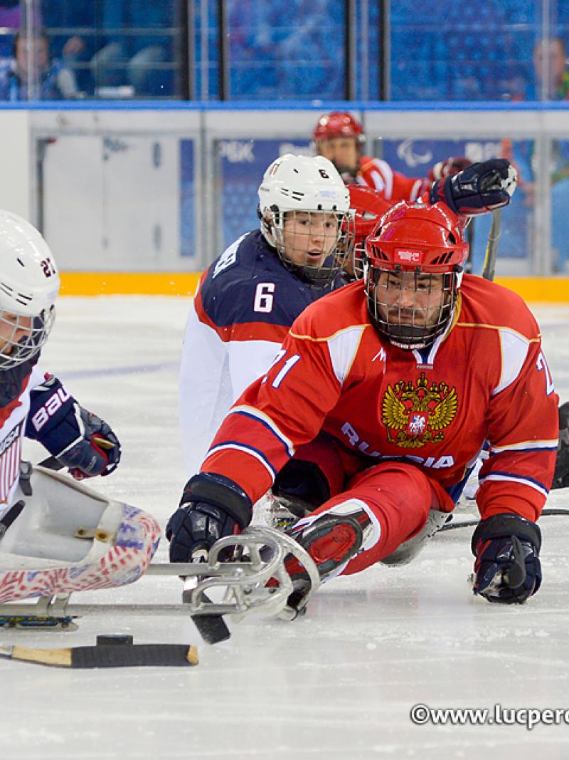 Evgeny Petrov tries to steal puck off Joshua Pauls