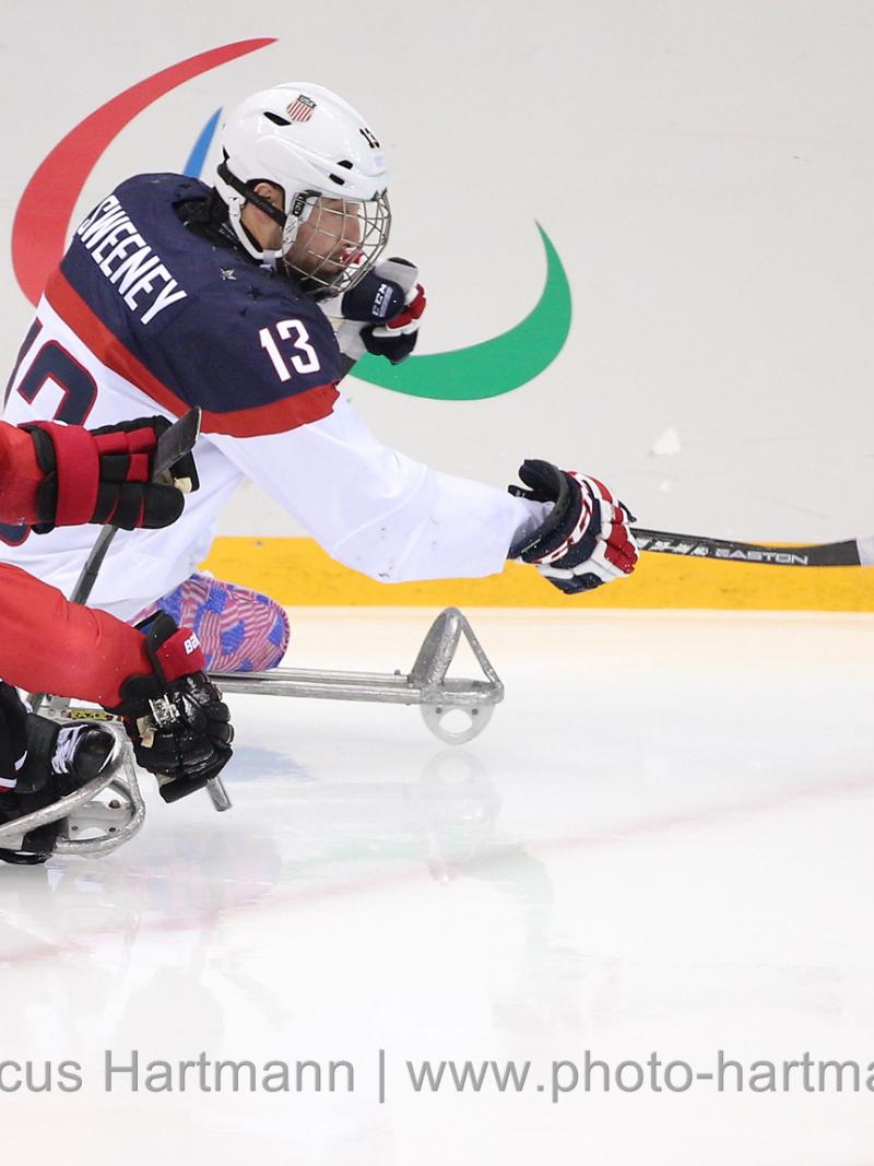 Canads's Brad Bowden and the USA's Josh Sweeney race for the puck during Sochi 2014.