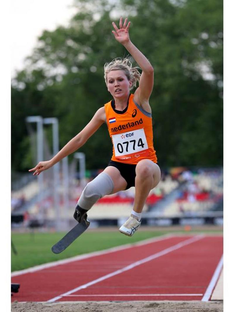 Blod women in orange jersey performing a long jump