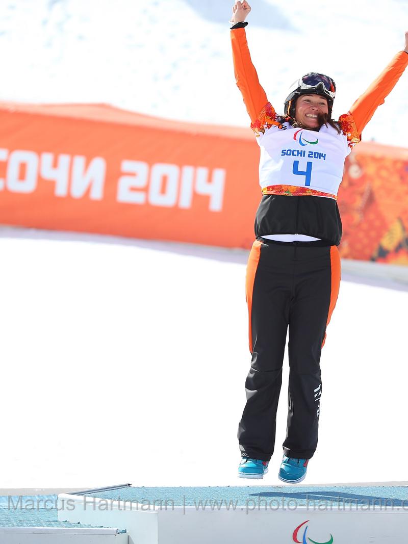 Bibian Mentel-Spee holds her arms high on the podium at the flower ceremony