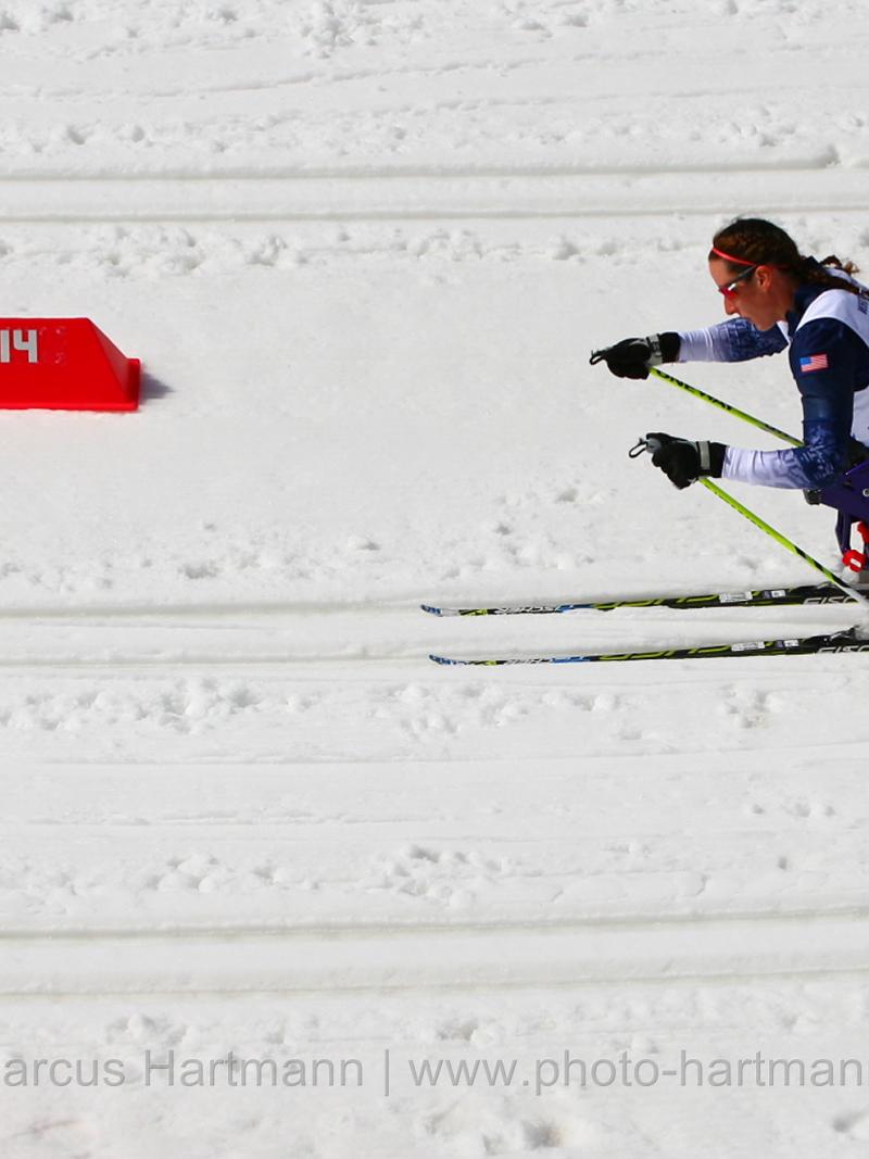 Women in sit ski on a cross country track