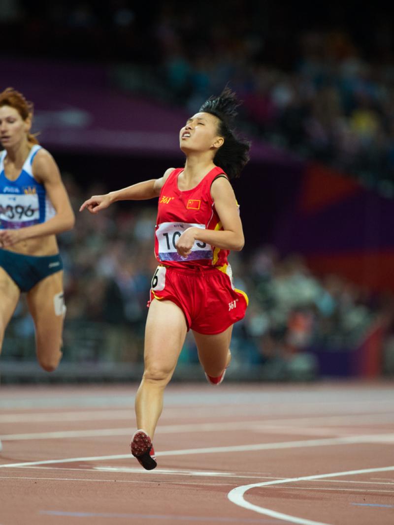 Four runners on a track in a stadium