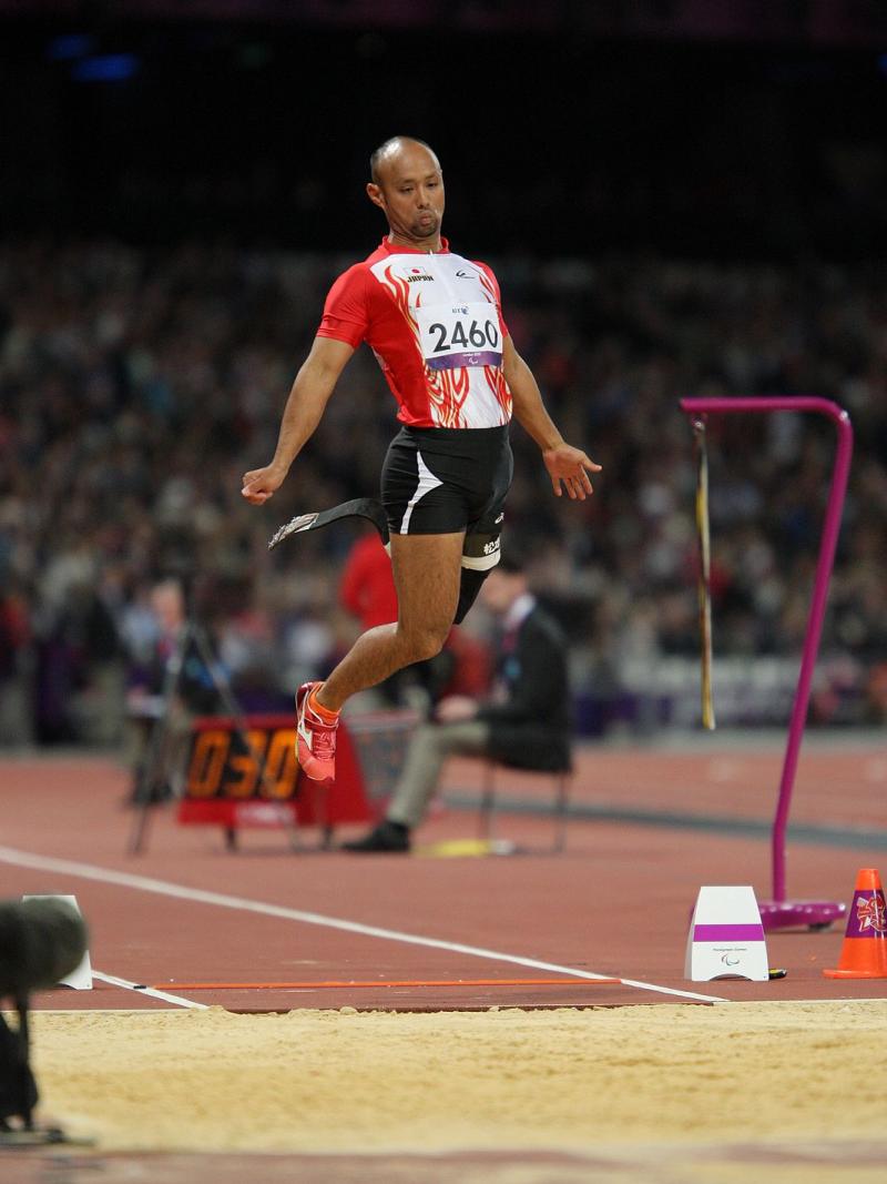 Man with prosthetic leg jumping in a stadium