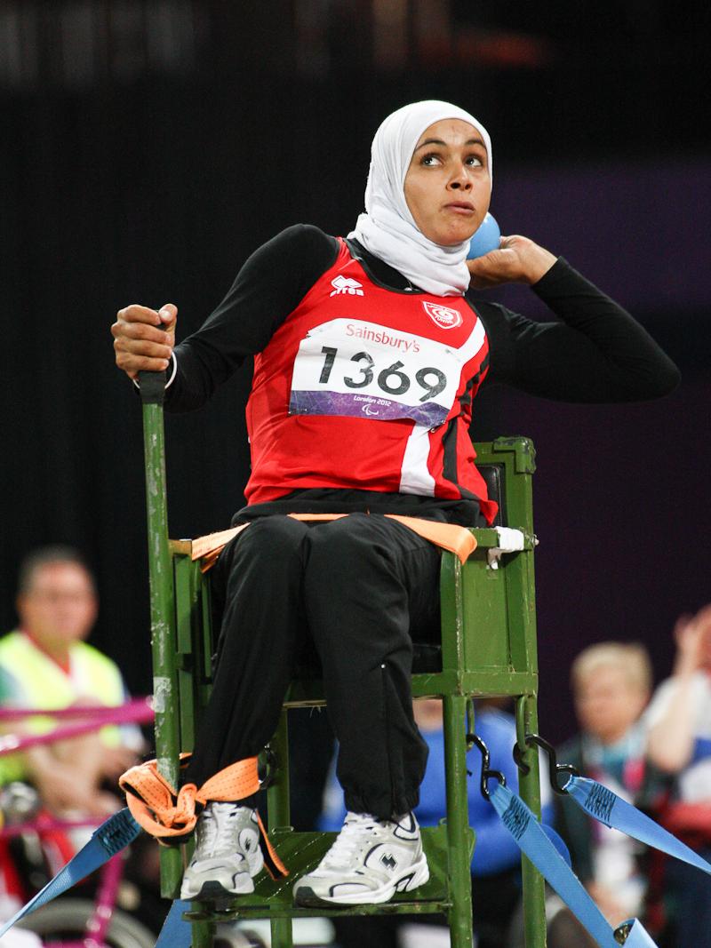 Women with headscarf doing shot put (sitting)