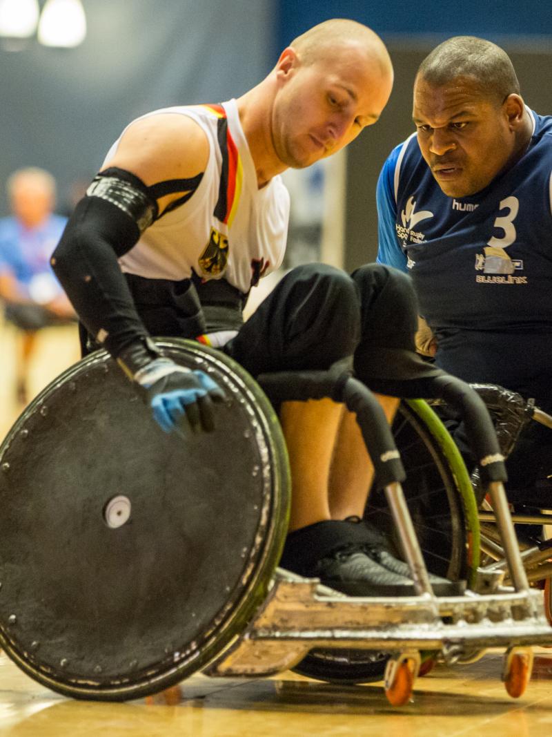 A French player wearing blue collides with his German opponent during a wheelchair rugby game.