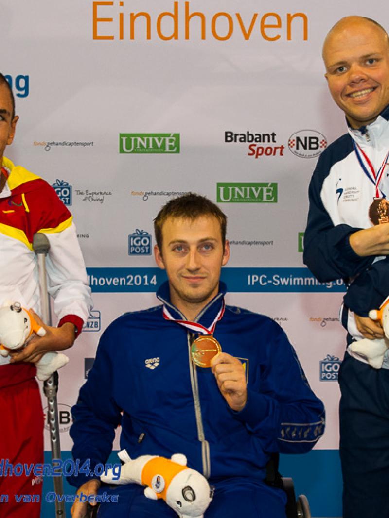 Dmytro Vynohradets poses with his latest gold medal alongside the silver and bronze medal winners at the 2014 IPC Swimming European Championships.