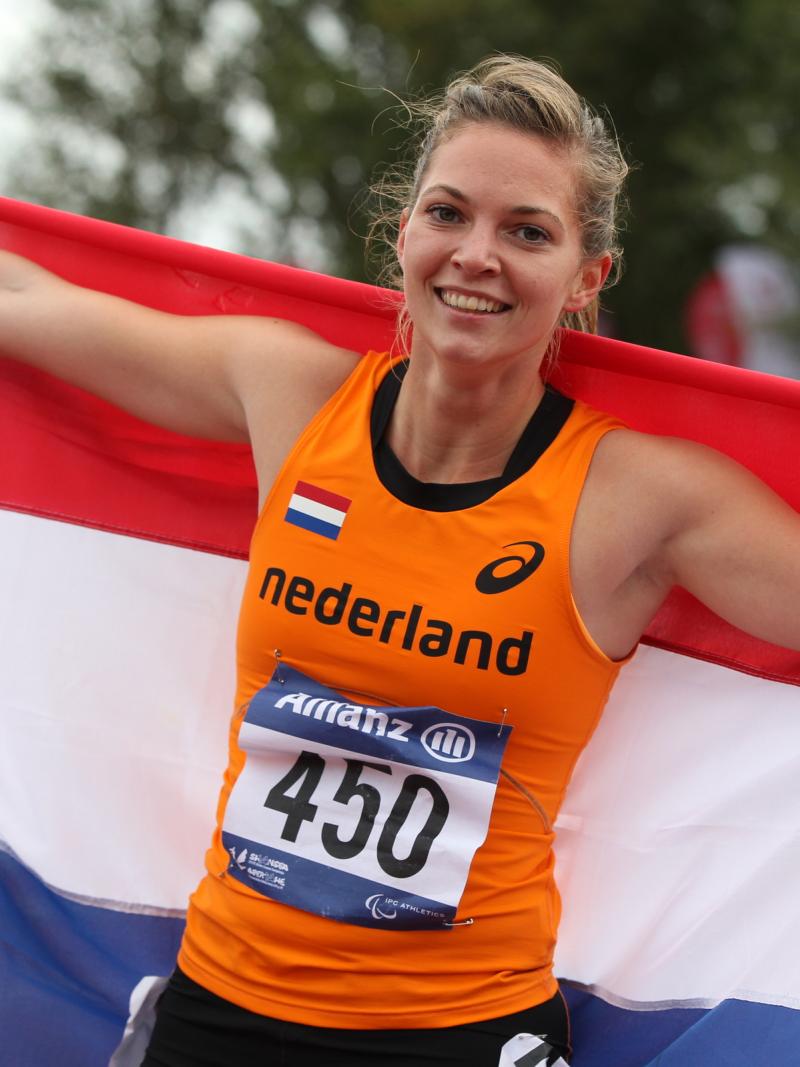 Women with a Dutch flag smiles to the camera