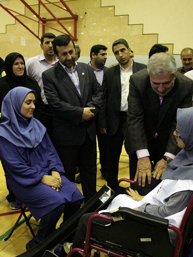 Men in suits in a conversation with two women in wheelchairs