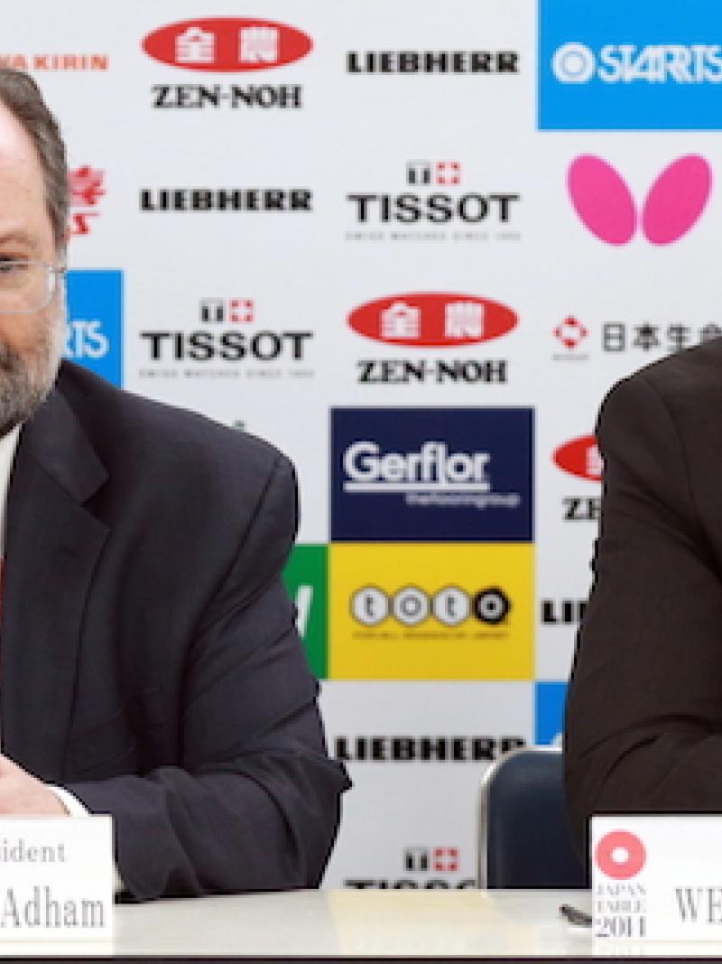 Two men on a press conference podium.