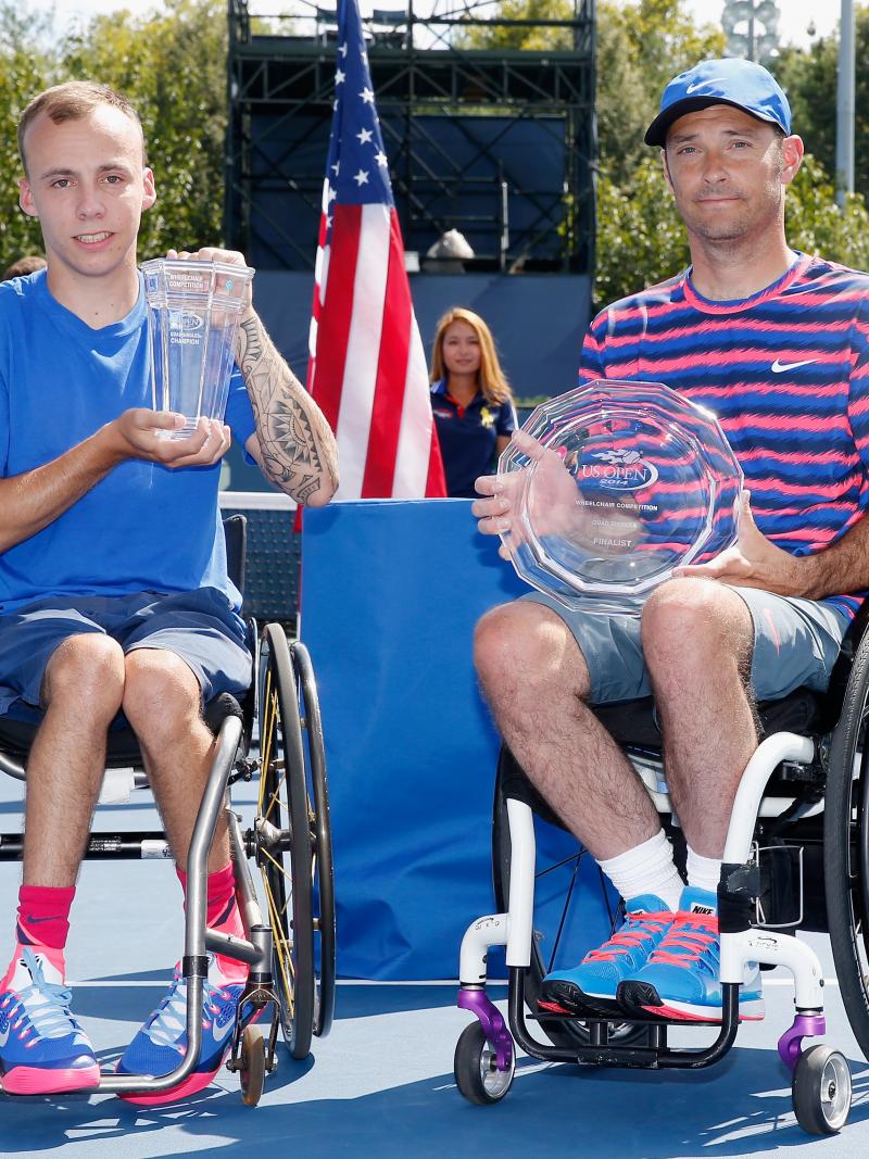 Great Britain's Andy Lapthorne (L) celebrates with the 2014 US Open trophy after defeating the USA's David Wagner (R) during the men's wheelchair quad singles final.