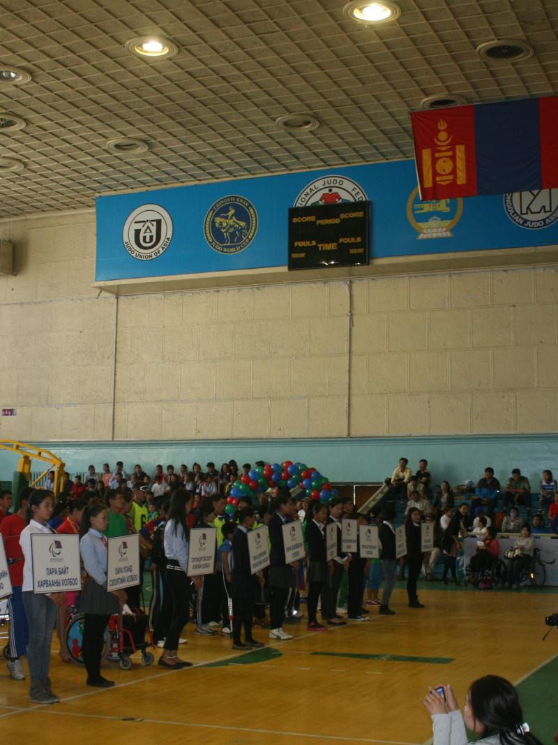 Many people in a room with some holding white signs