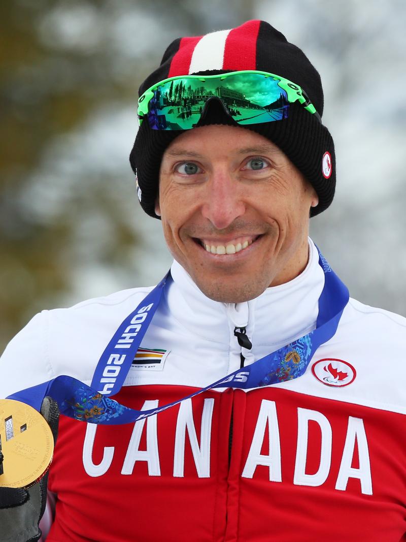 Upper body of smiling man holding medal