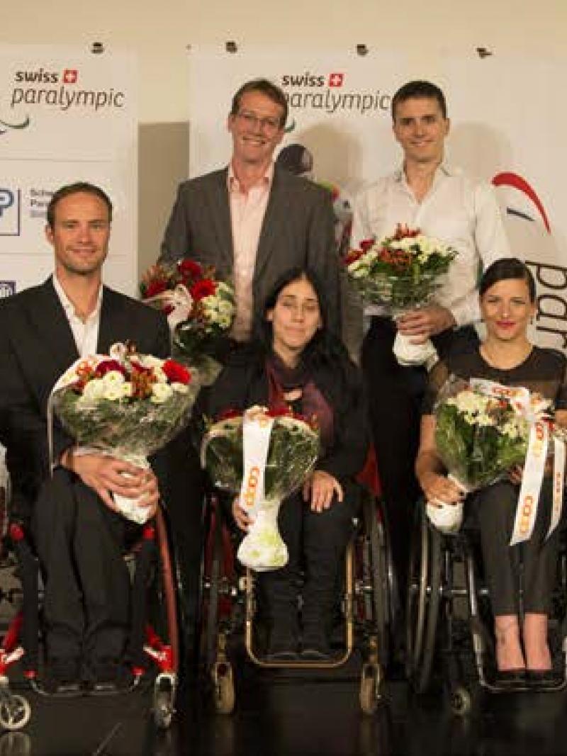 athletes holding flowers facing the camera