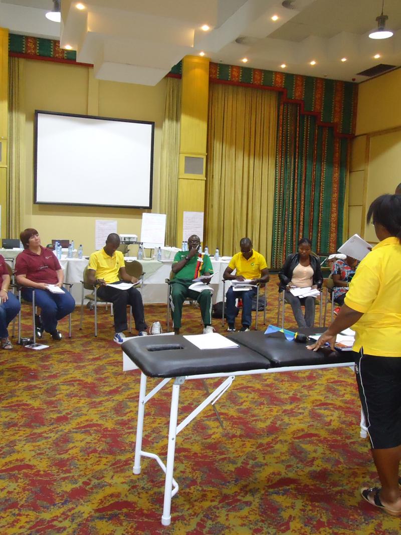 10 people in a workshop around a table with one person explaining.