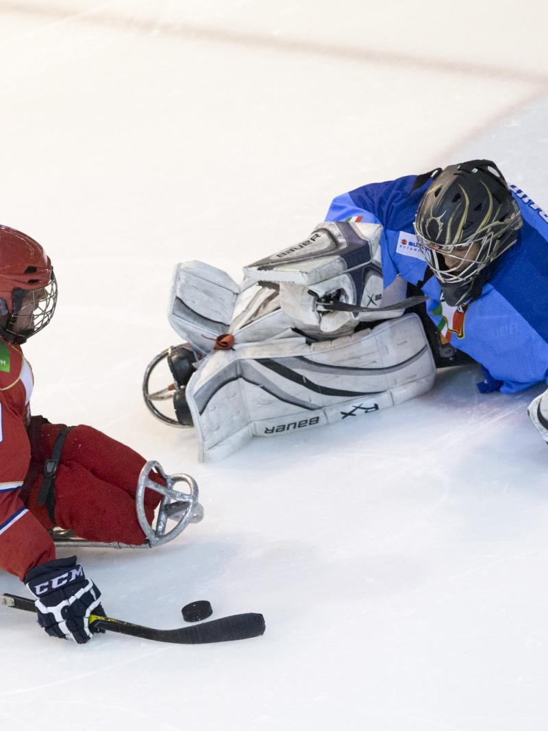 Ice Sledge Hockey player and goalkeeper face each other in a match.