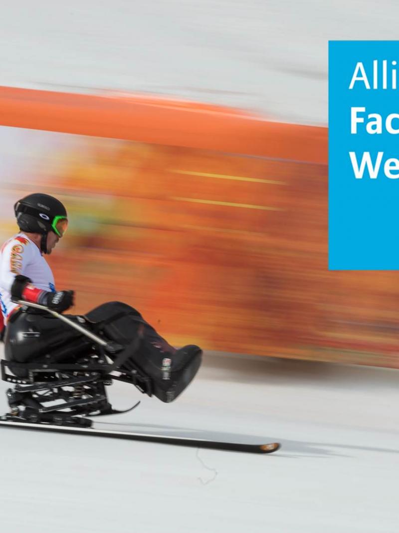 Skier in a sit-ski racing down a slope.